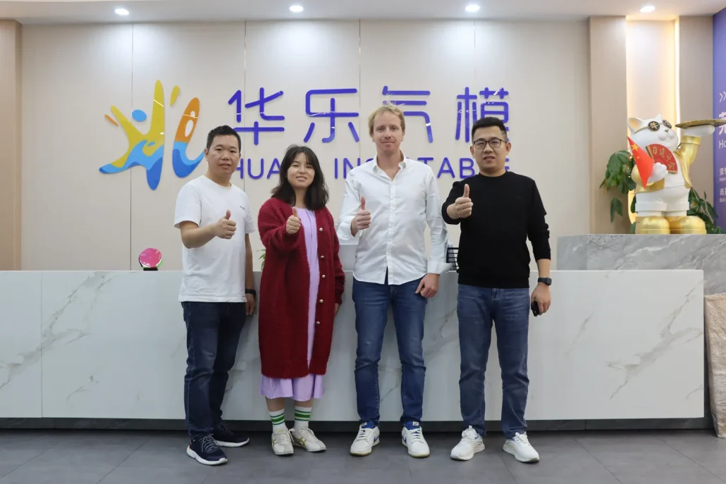 Group of people standing in front of a reception desk at Hua Inflatable office.