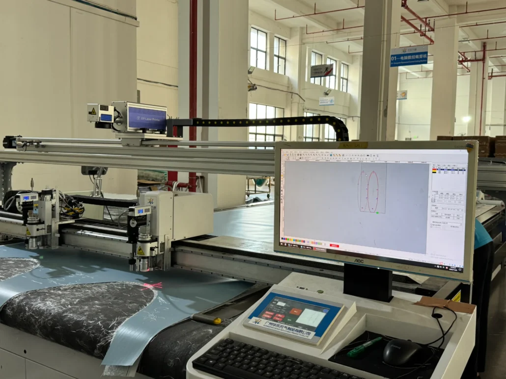 CNC laser cutting machine with precision control, showcasing software interface on a monitor, operating in a large industrial space.