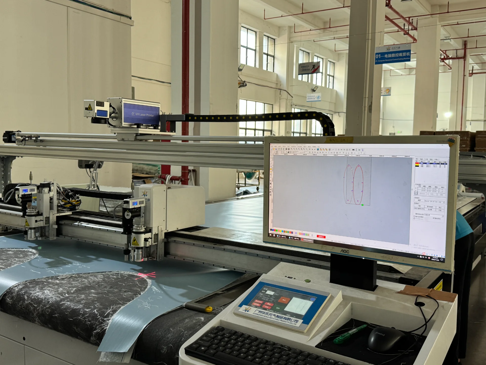 CNC laser cutting machine with precision control, showcasing software interface on a monitor, operating in a large industrial space.