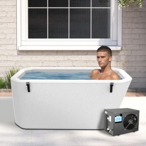 Person sitting in an outdoor ice bath near a brick wall, with a cooling machine next to the bath.