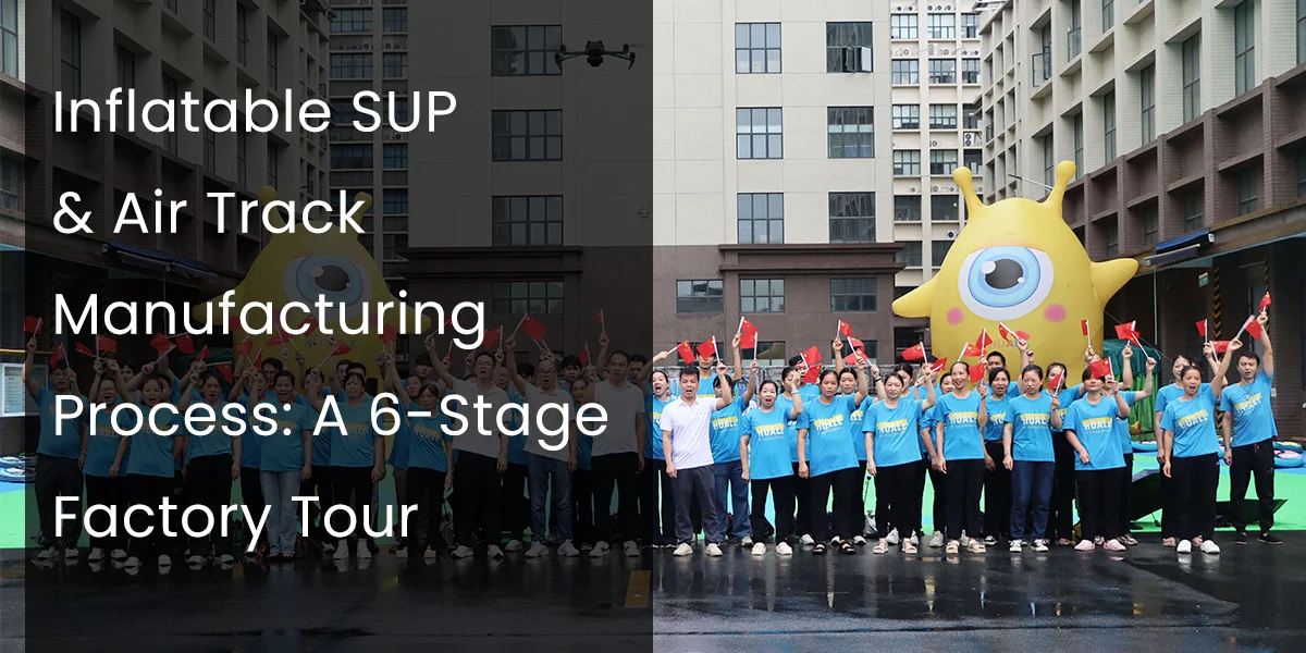 Group of factory workers in blue shirts holding flags, standing in front of an inflatable character during a factory tour.