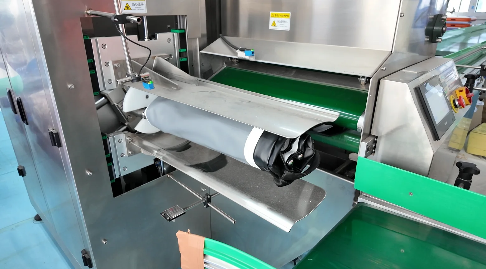 Close-up view of advanced industrial machinery with conveyor system, control panel, and metallic components.