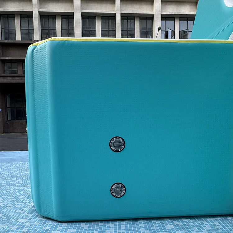 Close-up of a blue inflatable pool section with two valves on a tiled surface, against a building backdrop.
