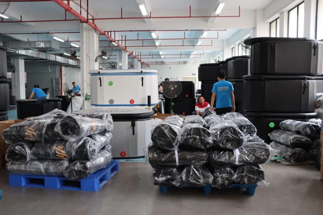 Stacks of hot tubs and materials in a factory setting with workers assembling products.