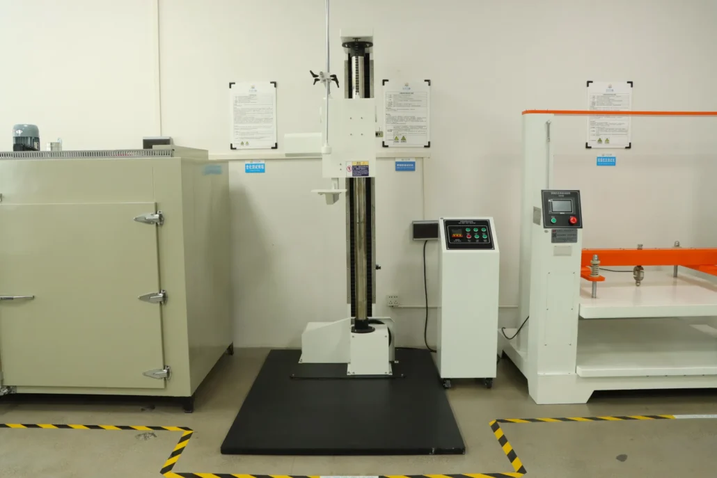Laboratory testing equipment in a facility, including a machine with a control panel, positioned between a large cabinet and another test machine.