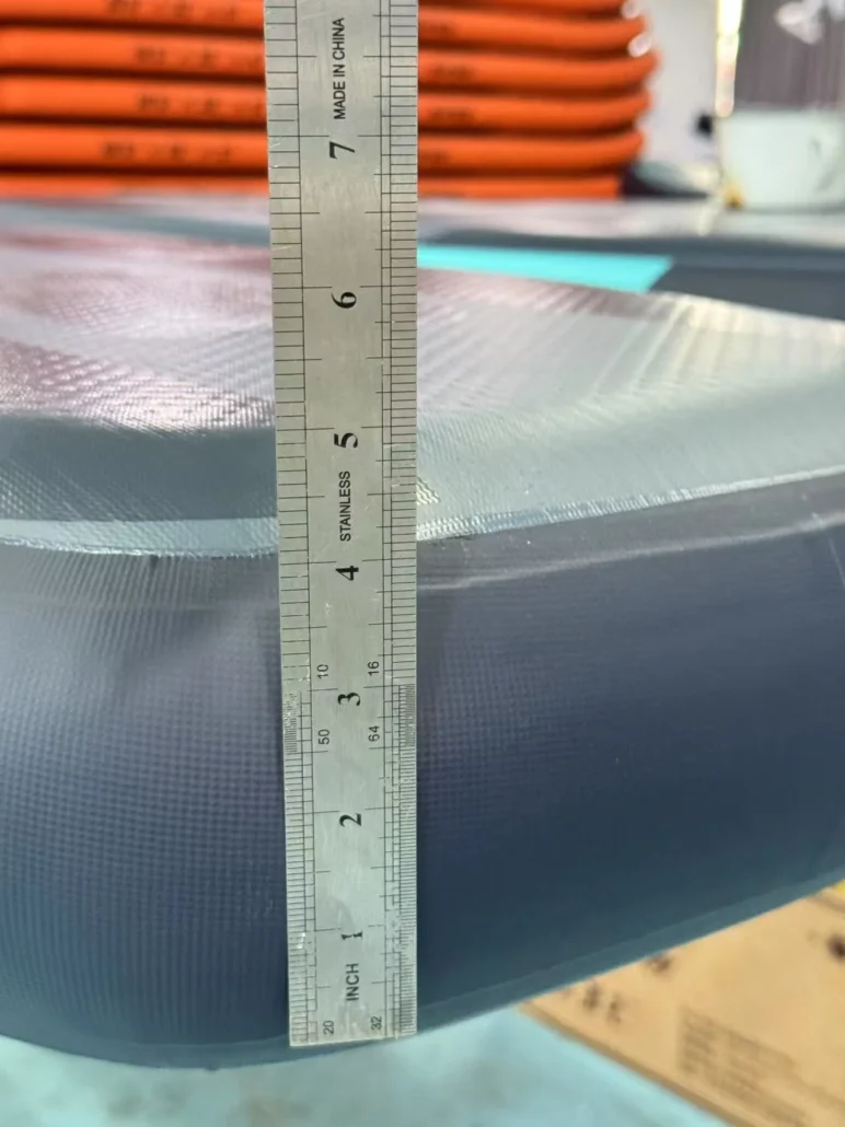 A metal ruler measuring the thickness of an inflatable object, with focus on precise measurement details.