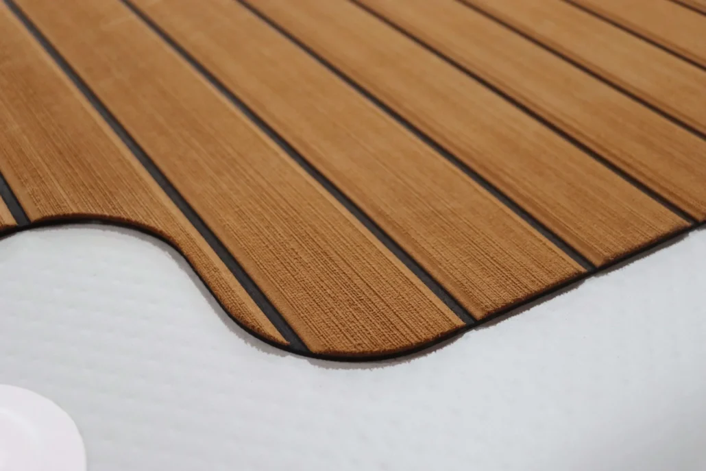Close-up of synthetic teak decking with wood grain pattern on a boat surface.