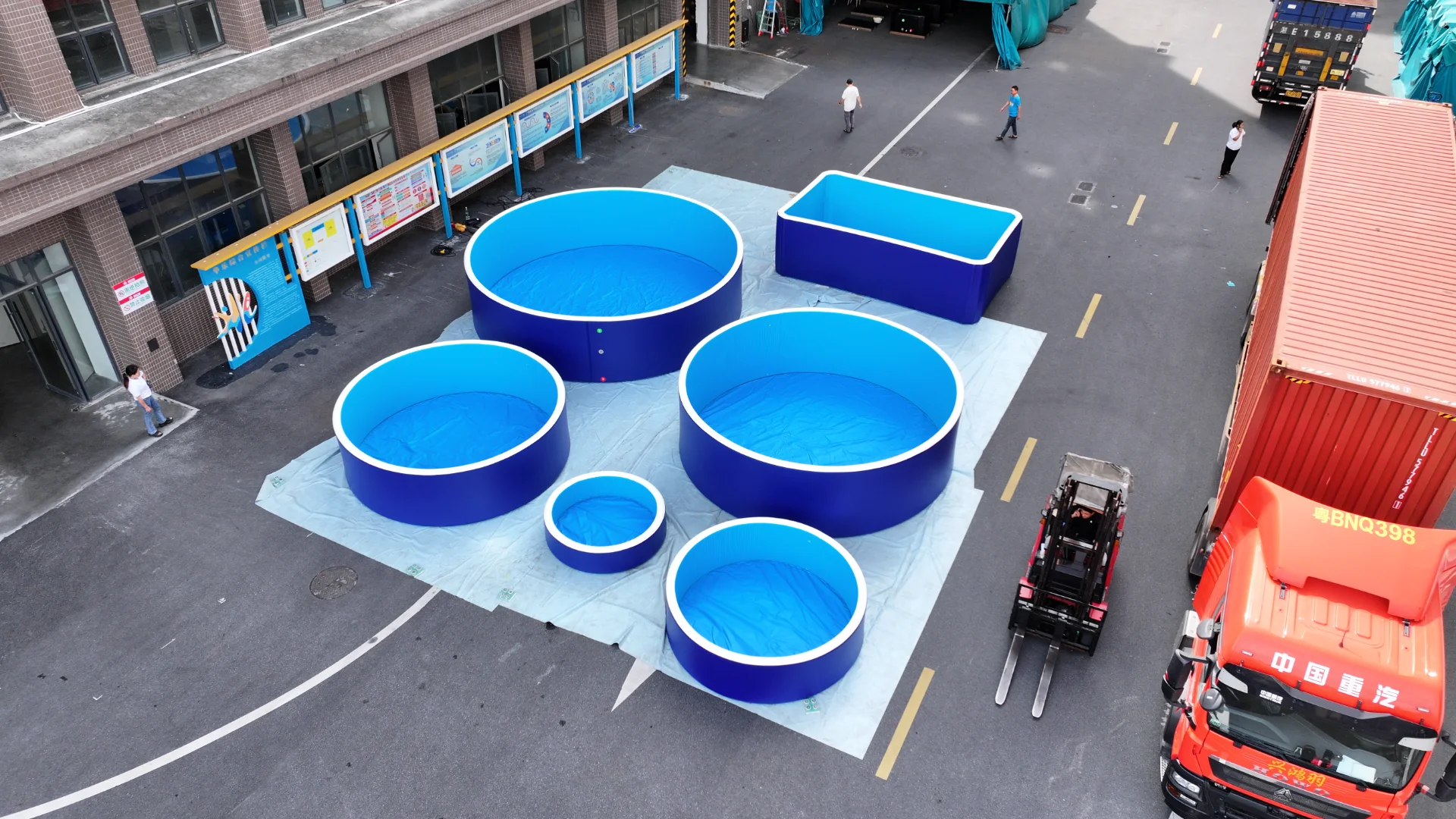 Blue drop stitch pools prepared in a factory yard