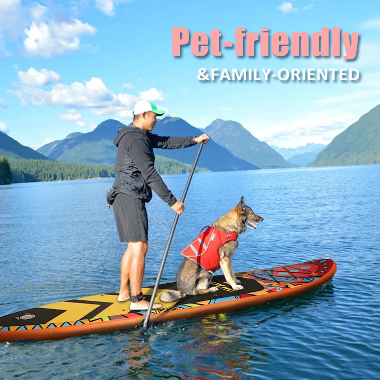 A man paddleboarding on a scenic blue lake with a dog wearing a red life jacket, set against mountains and a clear sky.