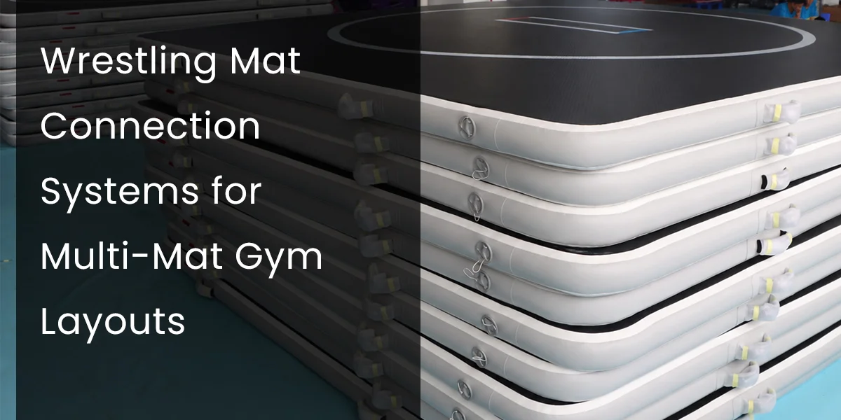Stack of white and black wrestling mats with connection systems for multi-mat gym layouts.