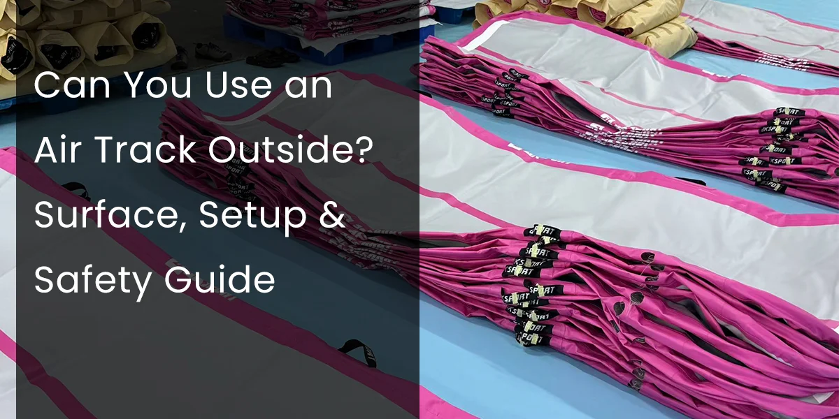 Rows of stacked pink and white air tracks placed on a blue floor with text overlay reading 'Can You Use an Air Track Outside? Surface, Setup & Safety Guide'.